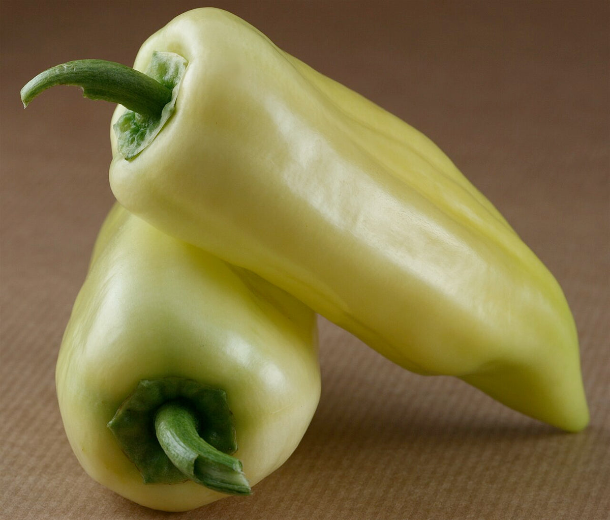 Banana peppers developing on a leafy plant