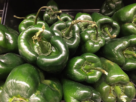 Fresh dark green poblano peppers grouped together