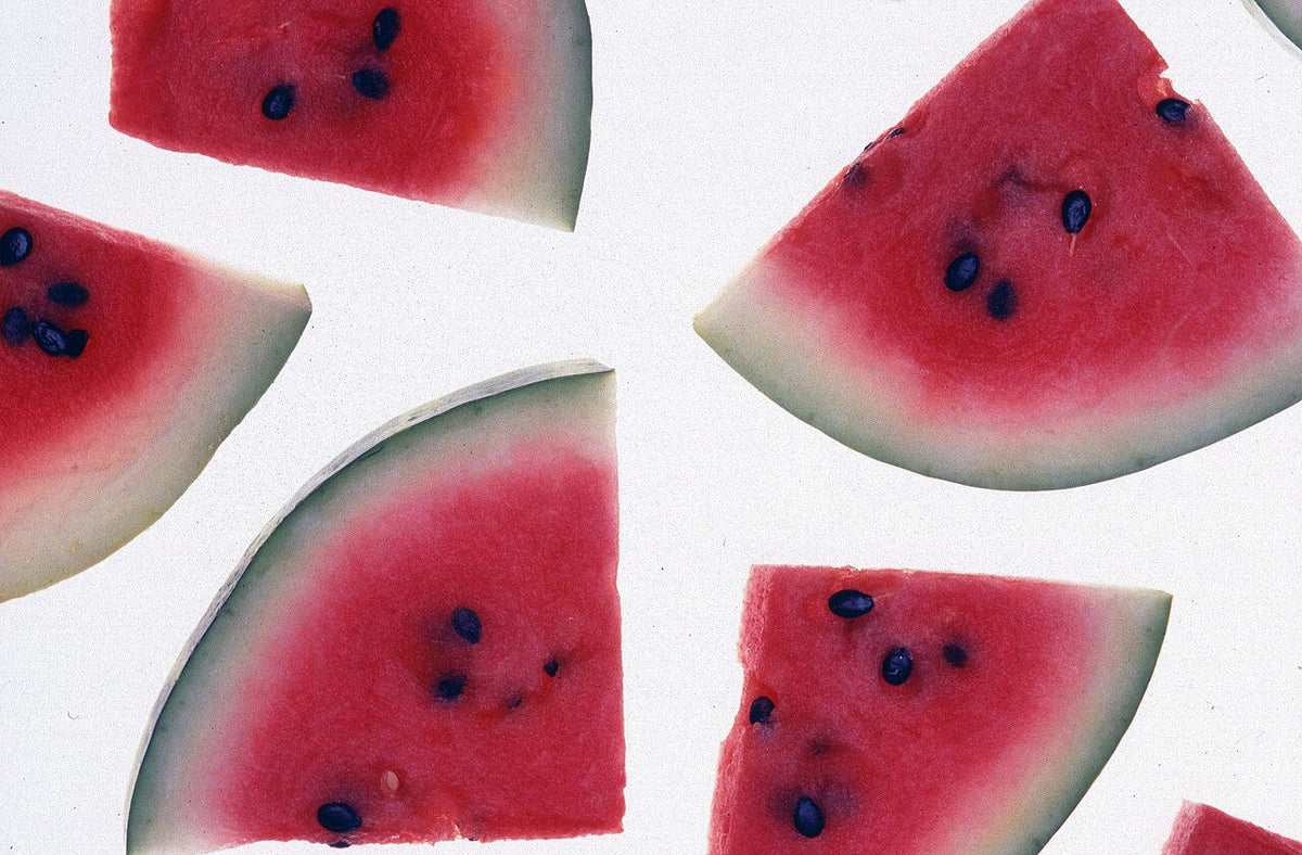Red watermelon wedges with dark seeds and pale inner rind